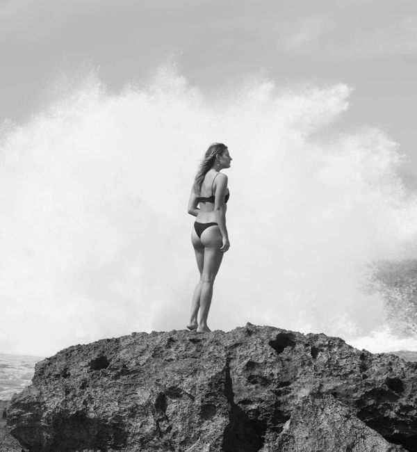 Woman outdoors feeling serene and full of energy with a calm landscape behind her.